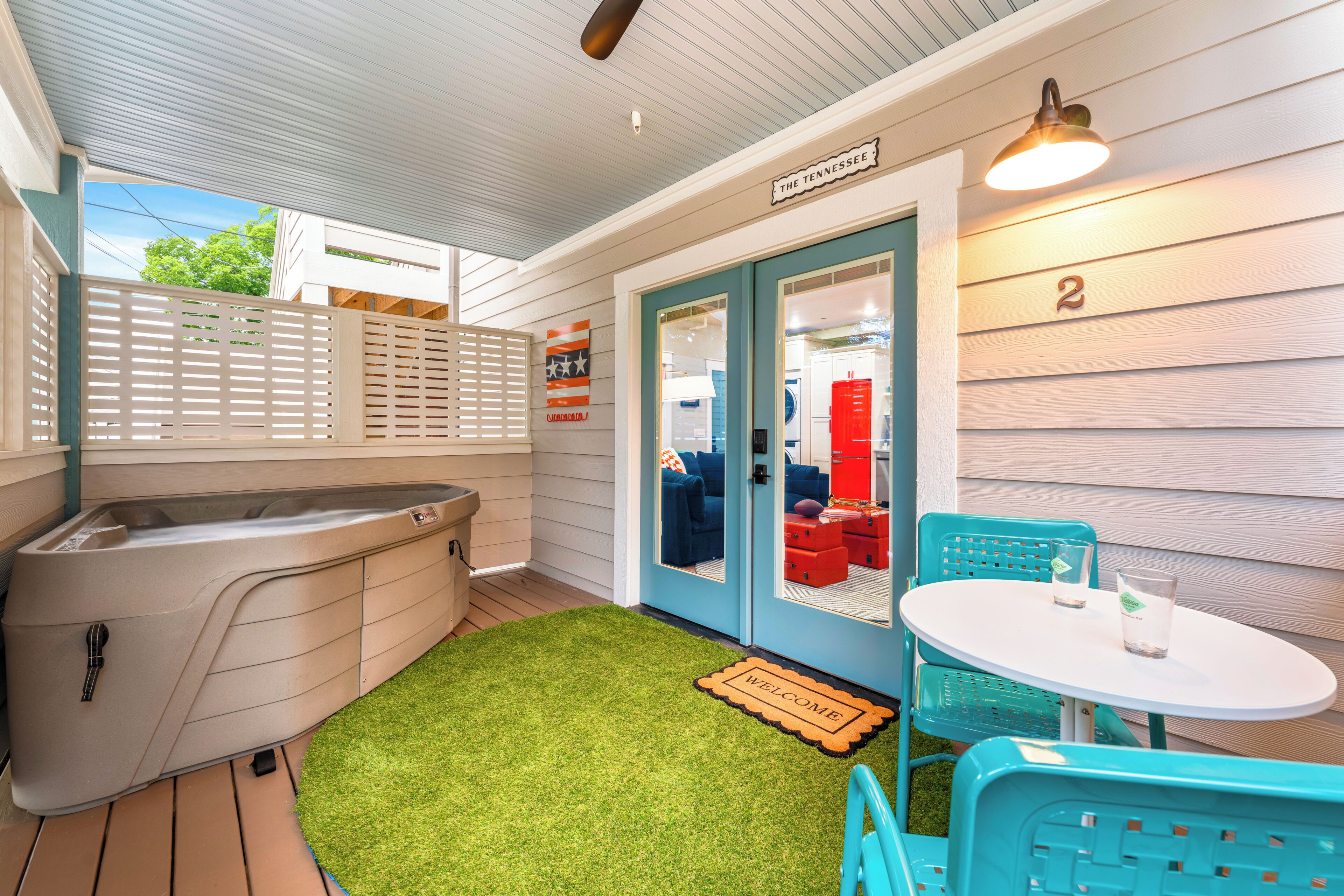 A spa area with a hot tub, a small table with chairs, and a door labeled 'The Tennessee.'
