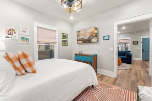 A bedroom with a bed, dresser, and artwork on the walls. - 1BR Hot Tub Suite • Tennessee (Sevierville)