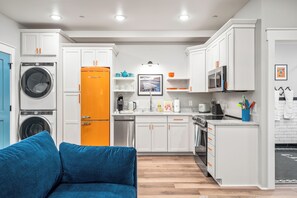 A compact kitchen with a washing machine, a microwave, and a sink. - 1BR Hot Tub Suite • Tennessee (Sevierville)