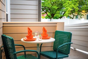 A small outdoor table with two chairs, a glass, and orange napkins. - 1BR Hot Tub Suite • Tennessee (Sevierville)