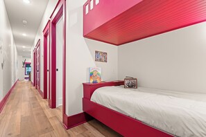 Ein Zimmer mit einem Etagenbett, einem kleinen Tisch mit Bilderrahmen und einer Wand mit einem Musikposter.