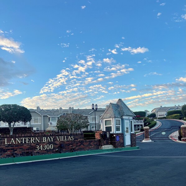A gated entrance to a residential area named "Lantern Bay Villas" with a brick wall and a clear sky. - Welcome to your dream retreat in Lantern Bay Villas (Dana Point)