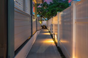 A narrow pathway flanked by white fences with small lights along the edges. - 1BR Hot Tub Suite • Butterfly (Sevierville)