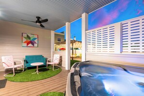 A patio area with a seating arrangement, a hot tub, and a view of the sky. - 1BR Hot Tub Suite • Butterfly (Sevierville)