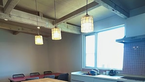 Una cocina moderna con una isla central, taburetes de bar e iluminación colgante.