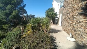Ein Weg, der zu einem Gebäude mit einer Steinauffahrt und blauem Himmel führt.
