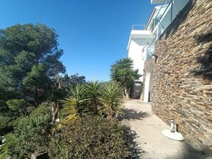 A pathway leading to a building with a stone facade and a clear blue sky. - Joan Margarit 24 With 4 Bedrooms and 3 Bathrooms (Roses)