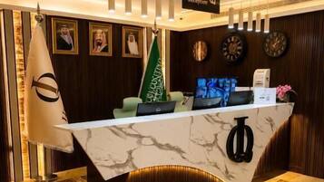 A reception desk with a marble top, a flag, and a sign indicating a reception area.