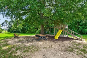 A playground with a slide, picnic table, and benches. - Modern Tifton Getaway - 3BR + Pool Access (Tifton)