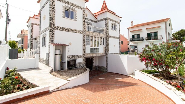 A residential building with a stone facade, a tiled roof, and a paved courtyard. - Spacious 5-Bedroom Villa with Garden Near Lisbon ,Sesimbra& beautiful beaches (Quinta Do Conde)