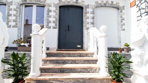 A building with a black door, white columns, and steps leading to the entrance. - Spacious 5-Bedroom Villa with Garden Near Lisbon ,Sesimbra& beautiful beaches (Quinta Do Conde)