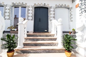 A building with a black door, white columns, and steps leading to the entrance. - Spacious 5-Bedroom Villa with Garden Near Lisbon ,Sesimbra& beautiful beaches (Quinta Do Conde)