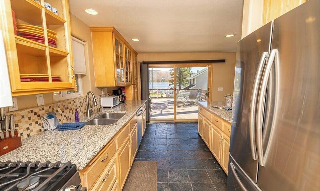 A kitchen with granite countertops, stainless steel appliances, and wooden cabinets.