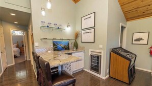 A kitchen with a granite countertop, white cabinets, a built-in oven, and a wooden ceiling. - Lakefront 4BR, Dock, Hot Tub, EV Charger, Dogs OK (Big Bear Lake)