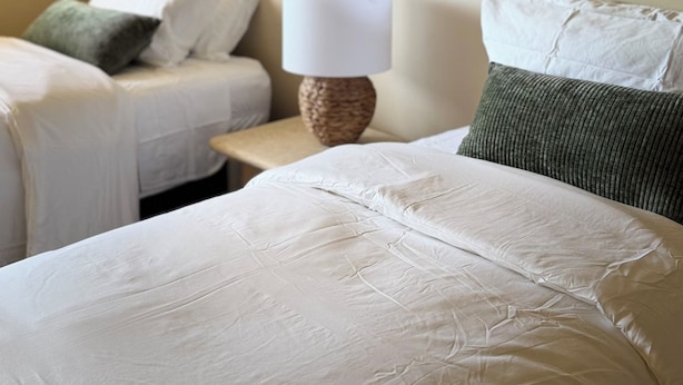 Una camera d'albergo con un letto, due comodini, una lampada e un quadro appeso al muro.