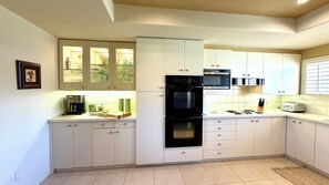 A modern kitchen with white cabinetry, a built-in oven, a microwave, and a coffee maker. - Indian Wells 3 bed retreat with incredible views, multiple pools and tennis (Indian Wells)
