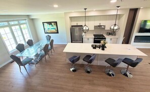 A modern kitchen with a central island, bar stools, and a dining table with chairs. - Great townhome in a family-friendly neighborhood (Ajax)