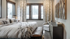 A bedroom with a large bed, a bench, a desk, and a window with curtains. - Sleek Mountain-Modern Townhome, Tucked in a Private Truckee Community (Truckee)