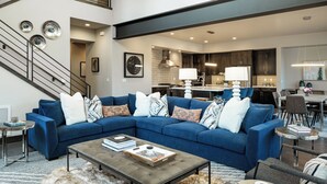 A modern living room with a sectional sofa, a coffee table, and a staircase. - Sleek Mountain-Modern Townhome, Tucked in a Private Truckee Community (Truckee)