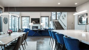 A modern kitchen with a dining area, large windows, and a staircase. - Sleek Mountain-Modern Townhome, Tucked in a Private Truckee Community (Truckee)