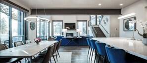 A modern kitchen with a dining area, large windows, and a staircase. - Sleek Mountain-Modern Townhome, Tucked in a Private Truckee Community (Truckee)