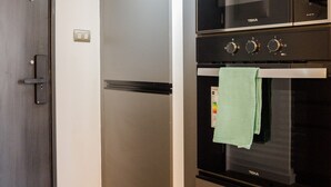 A modern kitchen with a built-in oven, microwave, and refrigerator. - Seminario Apartments by Andes STR (Ñuñoa)