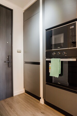 A modern kitchen with a built-in oven, microwave, and refrigerator. - Seminario Apartments by Andes STR (Ñuñoa)