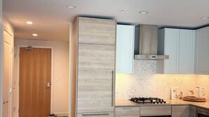 Cocina moderna con estufa integrada, horno y gabinetes de acero inoxidable.