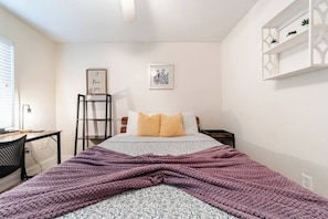 A bedroom with a bed, a desk, a chair, a ladder, and a shelf with plants. - Spacious 4BR | Near UF & Shands | Pool + Gym (Gainesville)