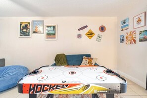Une pièce comprenant une table de hockey, un lit et des éléments de décoration murale sur le thème de la Floride.