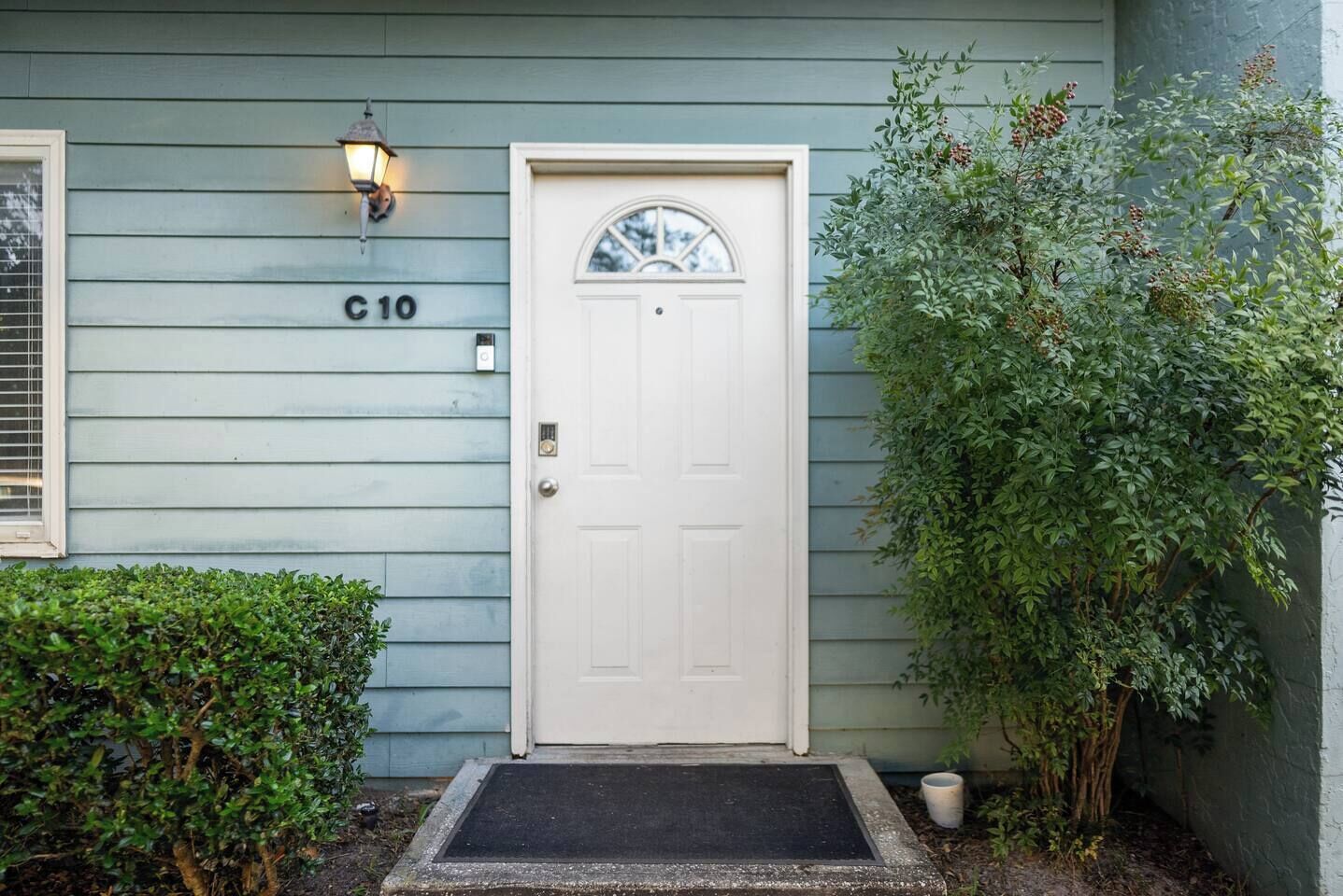 A house with a white door, a mailbox, and a number 'C10' on the wall.