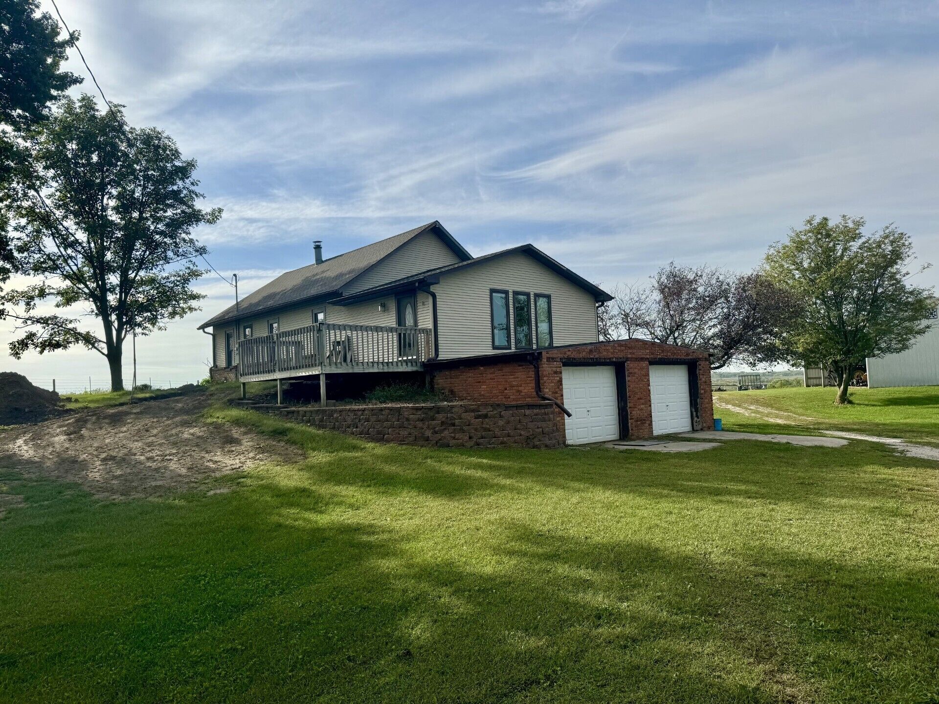 A two-story house with a covered porch and a brick garage.