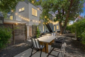 A modern house with a patio, outdoor seating, and string lights. - 3 Levels of Living 2 Lounges, 2 K Suites + Pool Table E ATX Outdoor Living (Austin)