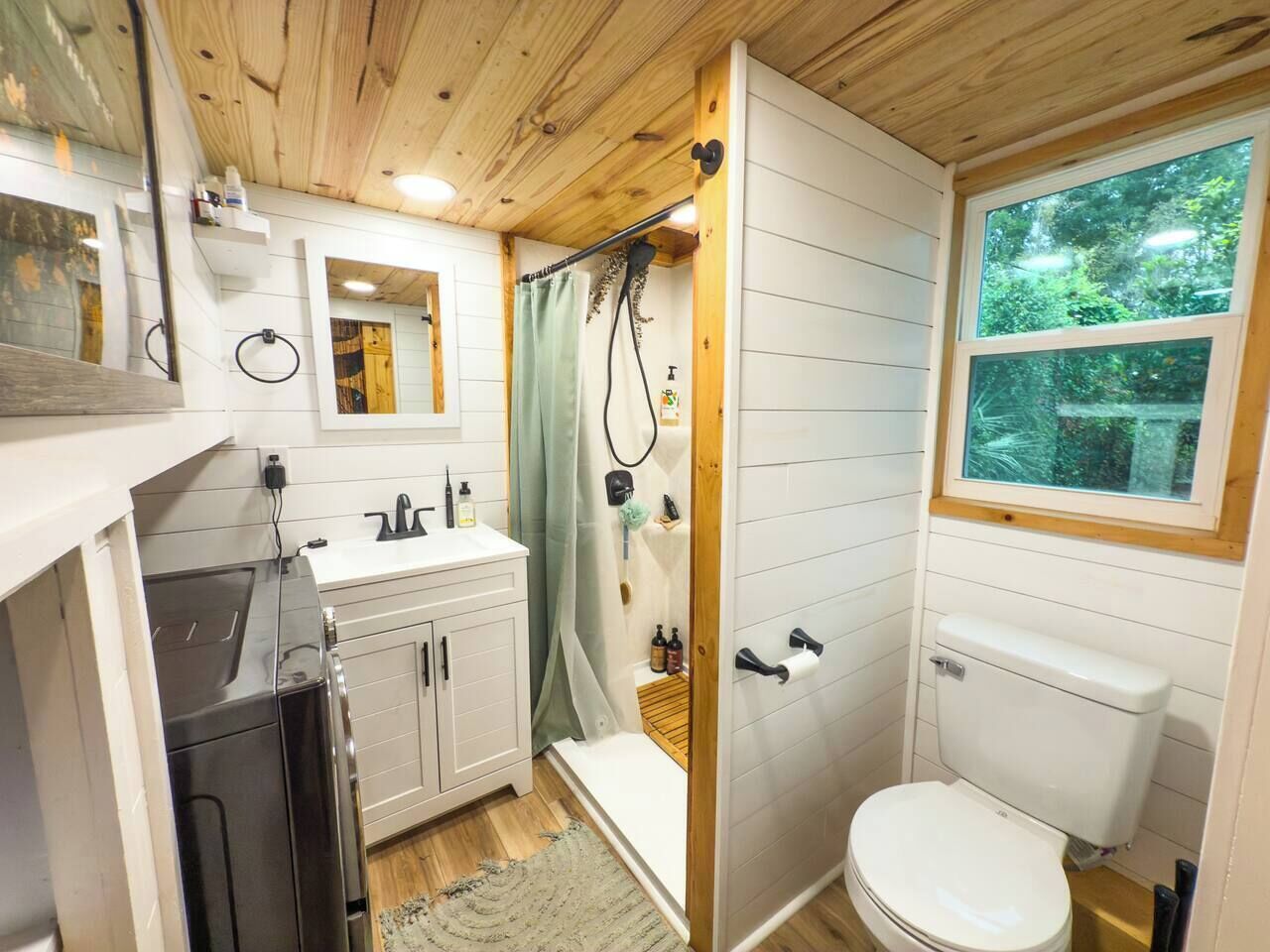 A compact bathroom with a shower, toilet, and sink.