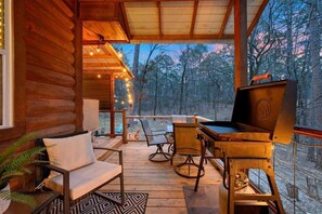 A wooden cabin with a deck, outdoor seating, and a grill. - Beaver's Little Lodge I Couples Cabin I Romantic (Hochatown)