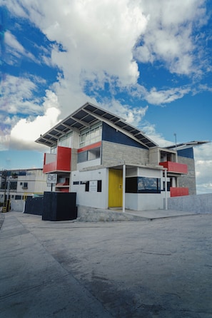 A modern building with a flat roof, large windows, and a prominent yellow door.