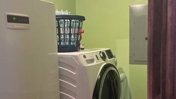 Un espace buanderie équipé d’un lave-linge et d’un réfrigérateur.