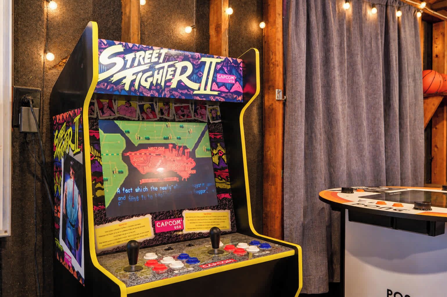 Une borne d’arcade du jeu Street Fighter II, dotée d’un écran aux couleurs vives et d’une table sur laquelle est posée une table de jeu de pong.