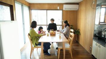 A family dining at a wooden table with a view of the outdoors.