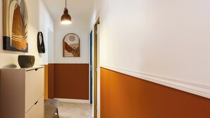 Passadís de disseny modern, amb una làmpada penjant, una obra d'art emmarcada i una porta que dona a una altra habitació.