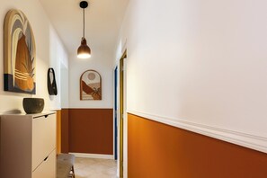 A hallway with a modern design, featuring a pendant light, a framed artwork, and a door leading to another room. - Villa Masté - Piscine - Clim - Verdon (Aups)