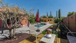 Un pati amb piscina, gandules i un pont de fusta.