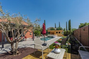 A backyard with a swimming pool, lounge chairs, and a wooden deck. - Villa Masté - Piscine - Clim - Verdon (Aups)
