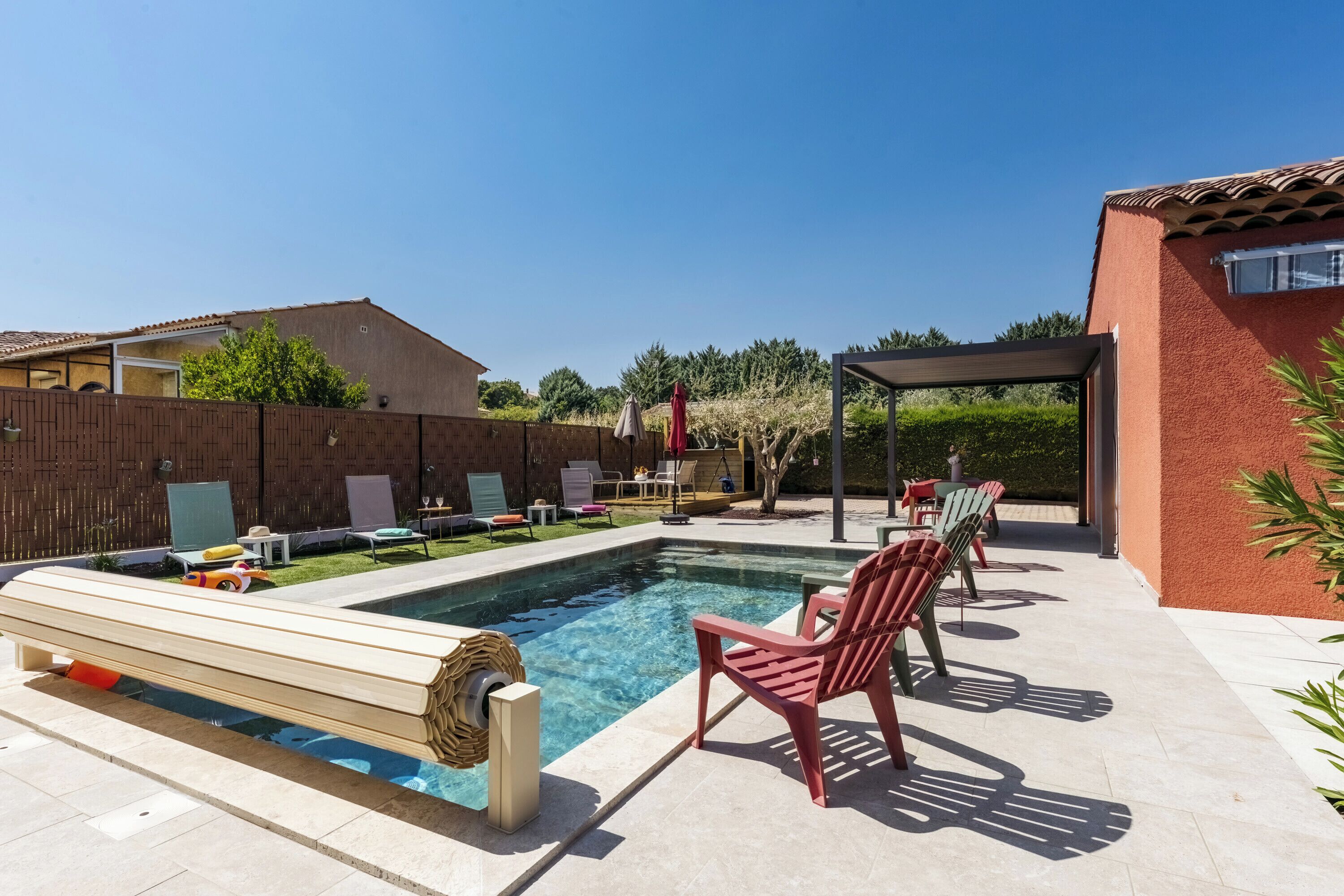 Ein Schwimmbecken mit Liegestühlen und einer Holzterrasse.