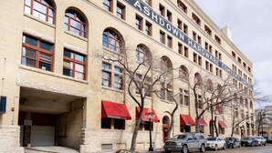 En historisk bygning med flere etager, store buede vinduer og et tydeligt skilt, der viser 'ASHDOWN HARDWARE COMPANY LIMITED'.