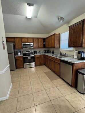A kitchen with wooden cabinets, stainless steel appliances, and a tiled floor. - Paradise Cove! Peaceful 3bedroom plus office home in friendly safe neighborhood! (Copperas Cove)
