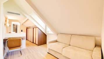 Un dormitorio estilo loft moderno con techo inclinado, escritorio empotrado, sofá acolchado y armario de madera.
