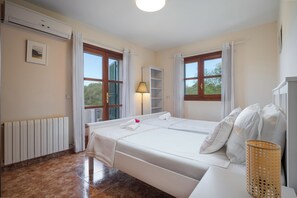 A hotel room with a bed, a radiator, a window with a view, and a lamp. - Casa Avrelia, a country house with a garden, pool, and gym, sleeps 8, near a golf course (IB)