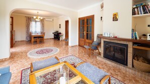 Una sala de estar amplia con chimenea, comedor y estantería.