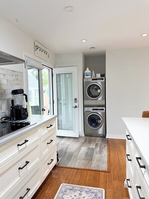 A laundry room with a washing machine, dryer, and a coffee maker on the counter. - The Athlete Retreat / Sauna / Cold plunge / red light / huge kitchen (Port Colborne)